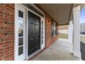 Close-up of the front door with sidelights, brick surround, and a covered porch area at 6311 Feather Run Dr, Indianapolis, IN 46237