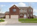 Classic brick two-story home with attached garages, front lawn, and inviting curb appeal at 6333 Silver Moon Ct, Indianapolis, IN 46259