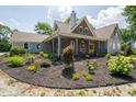 Beautiful front yard with mulched flower beds and vibrant plants leading up to a charming home with a welcoming porch at 695 N 650 W, Lebanon, IN 46052