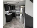 Modern kitchen with stainless steel appliances, gray flooring, and stylish backsplash at 730 Waldemere Ave, Indianapolis, IN 46241