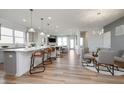 Open-concept kitchen and dining area with a large kitchen island, modern lighting, and wood-look flooring at 8381 Paxton Dr, Brownsburg, IN 46112