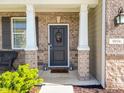 Close-up of the front door with a wreath, brick columns, and a 'hello' welcome mat at 9034 Faulkner Dr, Indianapolis, IN 46239