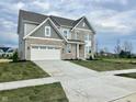 Beautiful two-story home boasts a gray brick facade, two-car garage, long drive way and a well-kept lawn at 1101 Knoll Ct, Greenwood, IN 46143