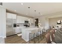 Bright kitchen boasts stainless appliances, a large island with seating, and stylish pendant lighting at 1101 Knoll Ct, Greenwood, IN 46143