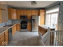Traditional kitchen with wood cabinets, stainless steel appliances, and a large island at 11569 Reagan Dr, Fishers, IN 46038