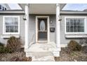 Inviting front entry with a classic door and a covered porch with decorative lighting at 1208 W 8Th St, Anderson, IN 46016