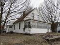 Two-story home with an enclosed porch and an attached structure on a spacious lot with mature trees at 290 S Marion St, Morgantown, IN 46160