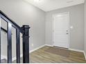 Clean and functional entryway featuring a white door, black railings, and sleek flooring at 2945 Kirkbride Way, Indianapolis, IN 46222