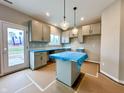 Bright kitchen with grey cabinets, a center island, stainless appliances and a door to the outside at 335 Atlas Dr, Lebanon, IN 46052