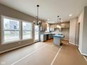 Bright kitchen with grey cabinets, an island, stainless appliances and large windows at 335 Atlas Dr, Lebanon, IN 46052