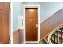 Hallway view of front door to unit 302 and stairwell with wood railing at 402 E New York St # 302, Indianapolis, IN 46202