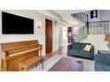 Inviting living room with hardwood floors, staircase, comfortable seating, and piano at 402 E New York St # 302, Indianapolis, IN 46202