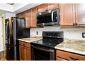 Kitchen features sleek black appliances, granite countertops, backsplash and wood cabinets at 4264 Foxglove Trce, Indianapolis, IN 46237