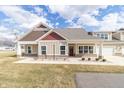 Charming home featuring neutral siding, red accents, a covered porch, and professional landscaping at 4408 W Preserve Pass, New Palestine, IN 46163