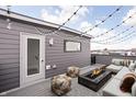 Relaxing roof deck featuring comfortable seating around a modern fire pit and string lights for ambiance at 447 Leota St, Indianapolis, IN 46203