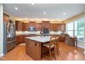 Well-lit kitchen features granite counters, stainless appliances, and wood floors at 651 Greenford N Trl, Carmel, IN 46032