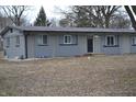 Exterior home view featuring gray siding, black roof, and yard with some shrubs and trees at 7144 Sandalwood Dr, Indianapolis, IN 46217