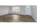 Neutral living room showcasing new floors, big window and lots of light at 7803 Delbrook Dr, Indianapolis, IN 46260