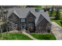 Aerial view of brick home with landscaped yard, driveway, and view of the lake at 895 Baywood Ct, Columbus, IN 47201