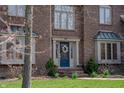 Close up of brick home showcasing a blue front door with decorative wreath and beautiful landscaping at 895 Baywood Ct, Columbus, IN 47201
