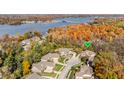 Aerial view showcasing the house within its scenic neighborhood near a lake and fall foliage at 9643 N Box Elder Ct, McCordsville, IN 46055