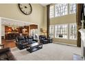 Bright living room with soaring ceilings, large windows, fireplace, and opening to the kitchen at 9643 N Box Elder Ct, McCordsville, IN 46055