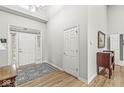 Bright entryway featuring hardwood floors, a decorative rug, and double doors at 10140 Cheswick Ln, Fishers, IN 46037