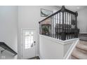 Inviting entryway with a white door, elegant staircase, and view to the living area at 12723 Apsley Ln, Carmel, IN 46032