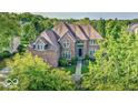 Beautiful brick home with a well-manicured lawn and mature trees surrounding the property at 13133 Brooks Landing Pl, Carmel, IN 46033