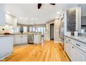 Bright kitchen with white cabinetry, stainless steel appliances, and hardwood flooring at 13661 Smokey Ridge Pl, Carmel, IN 46033