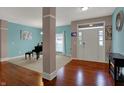 Inviting home foyer with wood floors, soft blue walls, white double door entry, and natural light at 14242 Brandt Ln, Carmel, IN 46074