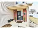 Cozy front porch with brick accents, small bench and manicured plants at 15281 Proud Truth Dr, Noblesville, IN 46060