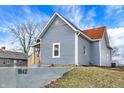 An exterior side view of a home with blue siding, complemented by a red roof and a neatly maintained yard at 1842 Tallman Ave, Indianapolis, IN 46218