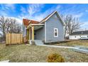 A charming house with blue siding, a red roof, a small front porch and a freshly landscaped yard at 1842 Tallman Ave, Indianapolis, IN 46218