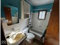 Compact bathroom with a combined tub and shower, toilet, and sink, ready for renovation at 2503 S Lyons Ave, Indianapolis, IN 46241