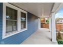 Inviting covered porch with blue siding and white columns, perfect for relaxing outdoors at 3011 N New Jersey St, Indianapolis, IN 46205
