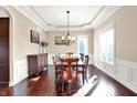 Formal dining room with tray ceilings, wood floors, and traditional furnishings at 3283 Homestretch Dr, Carmel, IN 46032