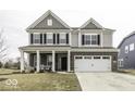 Charming two-story home featuring a brick facade, attached two-car garage and covered porch with seating area at 4078 Omaha Dr, Bargersville, IN 46106