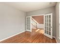 Open office space with hardwood floors and glass French doors leading to the foyer at 5344 Misthaven Ln, Greenwood, IN 46143