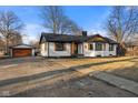 Attractive home featuring a bright exterior, complemented by a detached garage and neatly kept landscaping at 6470 Jackson St, Indianapolis, IN 46241