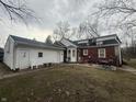 Spacious backyard with patio seating, a detached garage, offering relaxation and privacy at 6777 E Pleasant Run Pkwy S Dr, Indianapolis, IN 46219