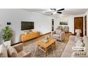 Staged living room features a plush sofa, chairs, area rug, and large-screen TV at 719 Howard Rd, Greenwood, IN 46142
