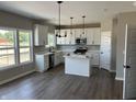 Bright kitchen with white cabinets, stainless steel appliances, island, and hardwood floors at 764 Oakleaf Dr, Greenfield, IN 46140