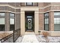 Inviting brick home exterior highlighting the front door with wreath and seasonal greenery at 946 Berkhamsted Ln, Carmel, IN 46032