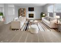 Bright living room featuring modern white furniture, fireplace, and striped rug creating an inviting space at 9924 Boysenberry Dr, Fishers, IN 46038