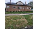 Durable brick home with manicured landscaping and brick-paved sidewalk along the side at 1001 S Anderson St, Elwood, IN 46036