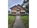 Inviting brick home with landscaped front yard, featuring a covered entryway and classic architectural details at 1001 S Anderson St, Elwood, IN 46036