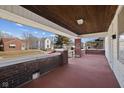Covered front porch with brick columns offering a cozy outdoor seating area and neighborhood views at 1023 W 7Th St, Anderson, IN 46016