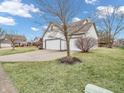 Traditional-style home featuring a three-car garage, lawn, and driveway at 10827 Putnam Pl, Carmel, IN 46032