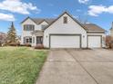 Traditional-style home featuring a three-car garage, lawn, and driveway at 10827 Putnam Pl, Carmel, IN 46032